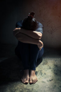 depressed woman sit alone in room corner